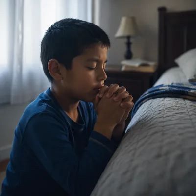 Young Boy Praying Beside Bed