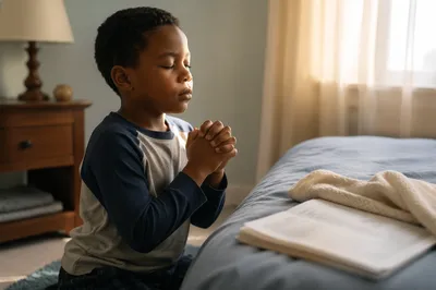 Young Boy Praying Beside Bed at Dawn