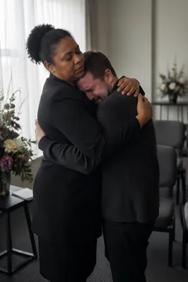 Compassionate Embrace at Indoor Funeral Reception