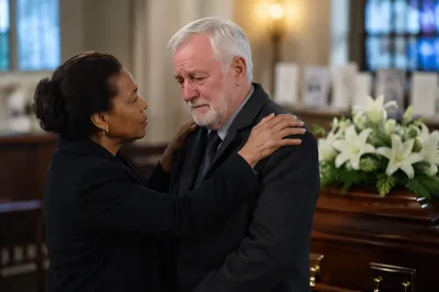 Comforting Embrace Beside Funeral Casket