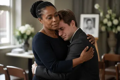 Comforting Embrace at Indoor Funeral Reception