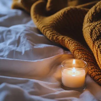 Warm Candlelight on Cozy Bedroom Blanket