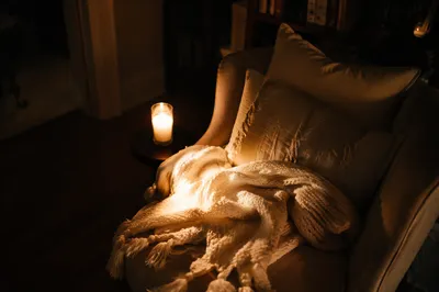 Cozy Armchair with Blanket and Candlelight