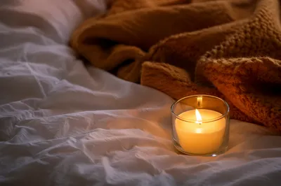 Warm Candlelight on Cozy Bedroom Bedding