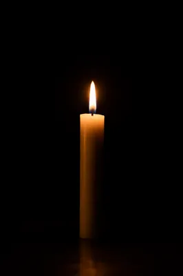 Single Candle Flame in Vast Darkness