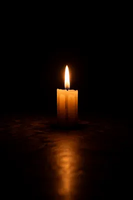 Single Ivory Candle in Darkness