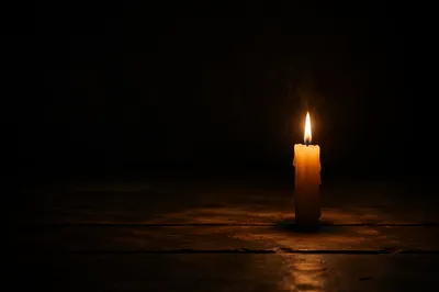 Single Candle Glowing in Dark Room