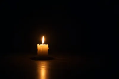 Single Candle Glowing in Dark Room
