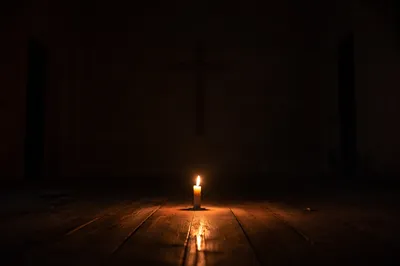 Single Candle of Courage in Dark Chapel
