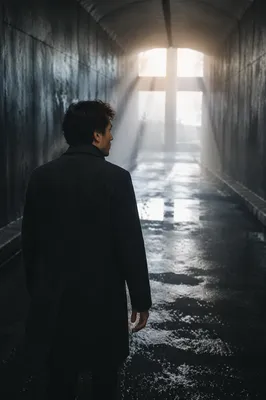 Man Walking Toward Light in Tunnel