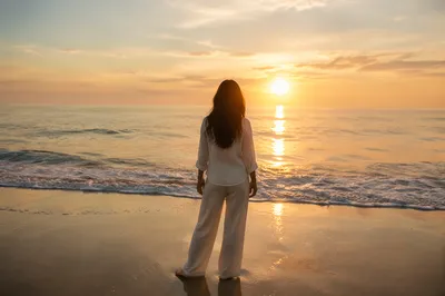 Woman at Sunrise Beach Facing Ocean