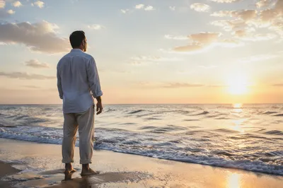 Man Watching Sunrise Over Endless Ocean