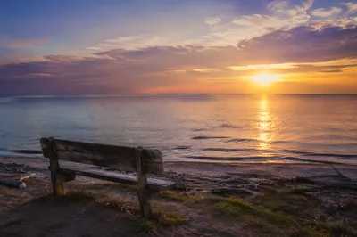 Sunrise Over Calm Ocean With Bench
