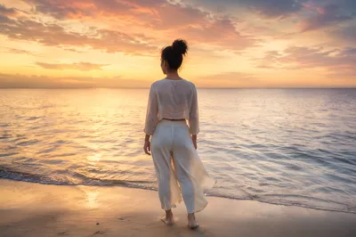 Woman Facing Sunrise Over Calm Ocean