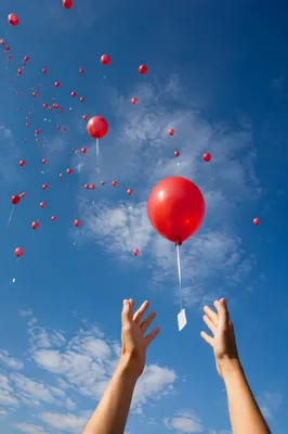 Hands Releasing Red Balloons of Forgiveness