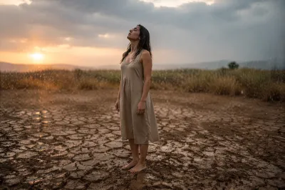 Young Woman in Rain on Dry Field