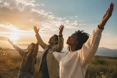 Diverse Group Raising Hands at Sunrise