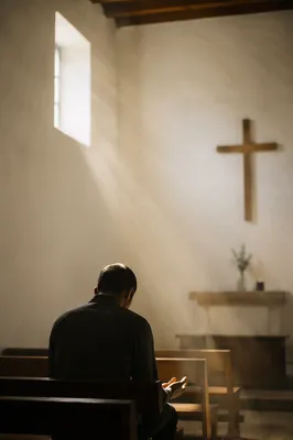 Bowed Figure in Gentle Chapel Light