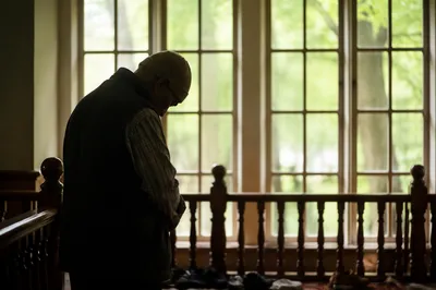 Humble Elder Bowed in Gentle Window Light