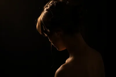 Bowed Head in Gentle Amber Light