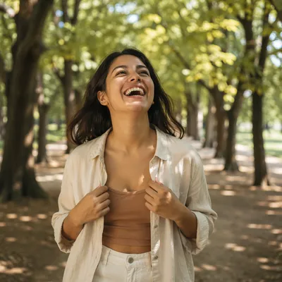Joyful Woman Laughing Beneath Sunlit Trees