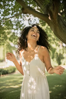 Joyful Woman Beneath Sunlit Tree