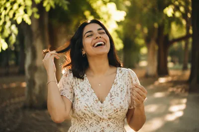 Joyful Woman Laughing on Sunlit Park Path