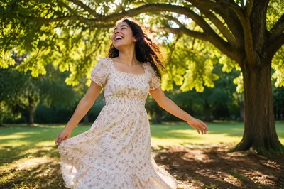 Joyful Woman Twirling Beneath Sunlit Tree