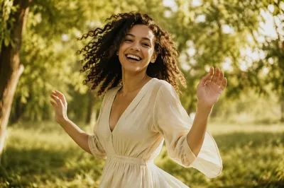 Joyful Woman Beneath Sunlit Park Trees