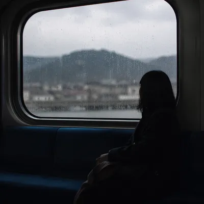 Lonely Figure Watching Rain Through Transit Window