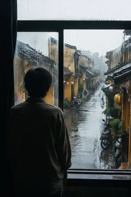 Lonely Figure Watching Rainy Alley Window