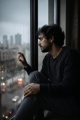 Solitary Man by Rainy Apartment Window