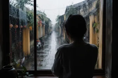 Lonely Figure Watching Rainy Alley Window