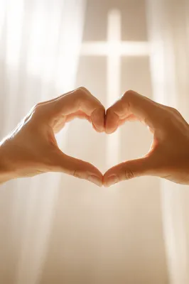 Hands Forming Heart with Cross Light