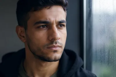 Determined Young Man by Rainy Window