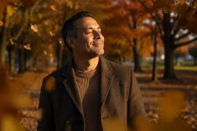 Content Man in Autumn Park Sunlight