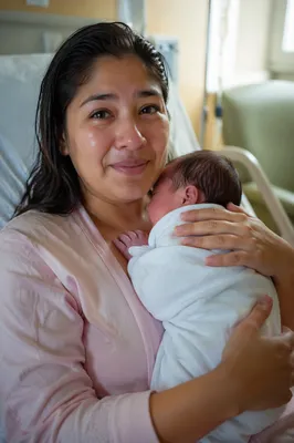 Emotional Mother Holding Newborn in Hospital