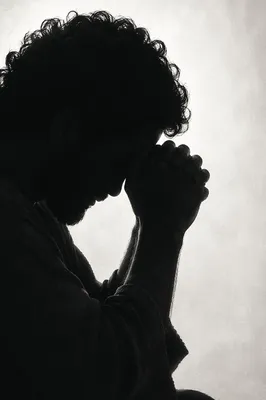 Overwhelmed Person in Prayerful Silhouette