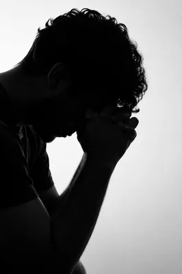 Overwhelmed Person in Prayerful Silhouette Portrait
