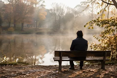 Solitary Bench Reflection by Autumn Pond