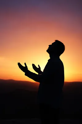 Praise Silhouette Beneath Golden Sunset Sky