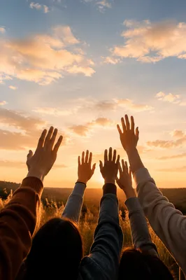 Raised Hands Against Golden Sunset Sky