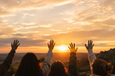 Hands Lifted in Golden Sunset Sky