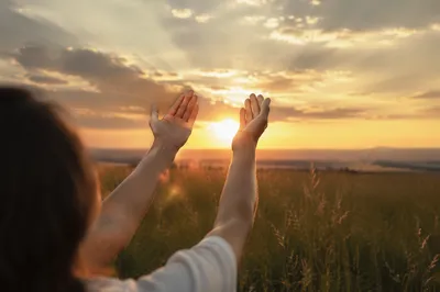 Hands Lifted in Praise at Golden Sunset