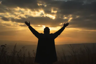 Silhouette Praising Under Golden Sunset Sky