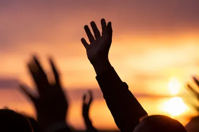 Raised Praise Hands at Golden Sunset