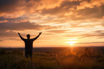 Praise Hands Lifted in Golden Sunset