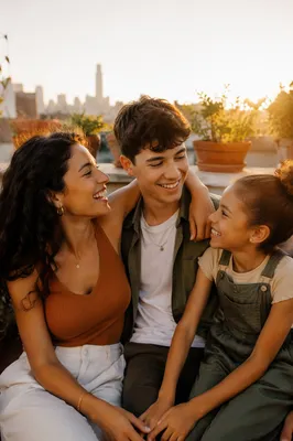 Three Siblings Laughing on Rooftop Garden