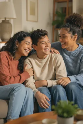 Three Siblings Laughing on Living Room Sofa