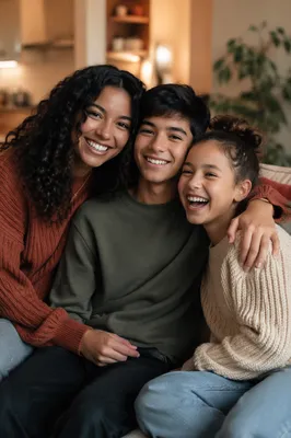 Three Siblings Laughing on Cozy Sofa